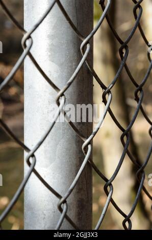 Primo piano di recinzione metallica a catena, modello a diamante, con profondità di campo ridotta o messa a fuoco selettiva, sfondo astratto o sfondo Foto Stock