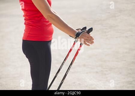 Primo piano di Female mani con Trekking Poles per Nordic Walking Foto Stock