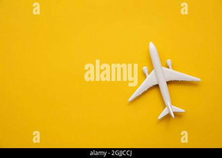 Aereo passeggeri bianco su sfondo giallo estivo. Background di viaggio e vacanza Foto Stock