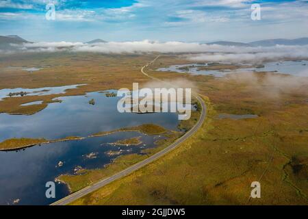 Vista di mattina presto di Rannoch Moor e della strada A82 nella nebbia da drone, Highlands scozzesi, Scozia, Regno Unito Foto Stock