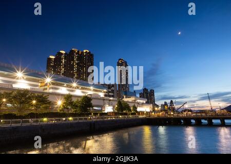 Vista notturna del paesaggio urbano degli edifici lungo la Waterfront Central Western District Promenade in Sheung wan, Victoria Harbour, Hong Kong Foto Stock