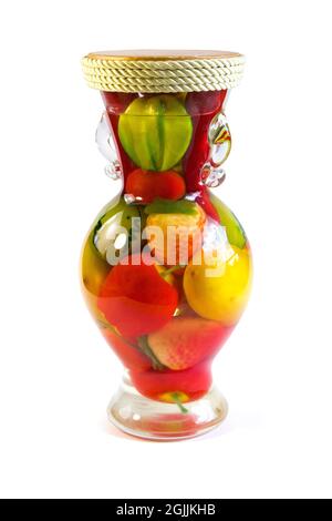 Composizione luminosa e colorata composta da frutti artificiali in vaso di vetro trasparente isolato su sfondo bianco Foto Stock