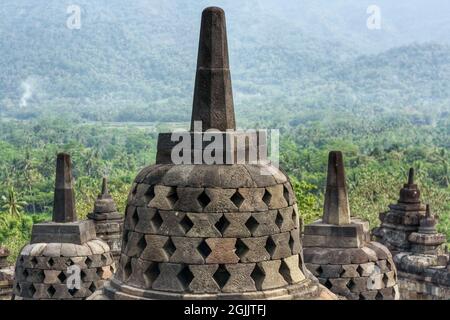 Interno dell'antico tempio Borobudur terrazza superiore con stupa che si affaccia su una collina e montagna. Nessuna gente. Popolare meta turistica e di pellegrinaggio Foto Stock