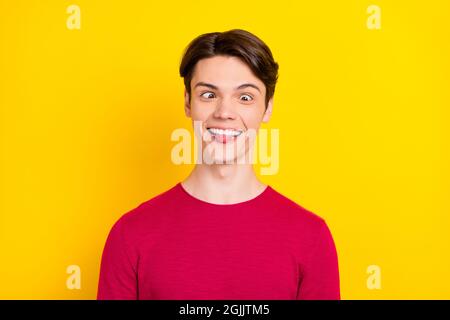 Foto di simpatico giovane gentiluomo indossare rosso pullover mostrando lingua sorridente isolato colore giallo sfondo Foto Stock