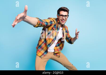 Foto di dolce funky giovane Signore indossare a scacchi camicia occhiali danza sorridente isolato sfondo di colore blu Foto Stock