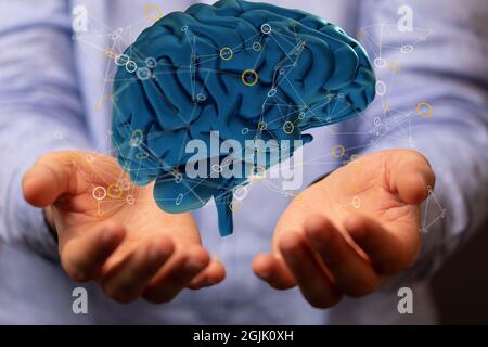 Primo piano di un concetto di test cerebrale artificiale sulle mani umane Foto Stock