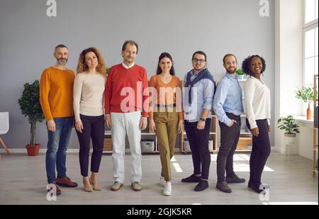 Gruppo di persone di età e nazionalità diverse in posizione in fila per la fotocamera Foto Stock