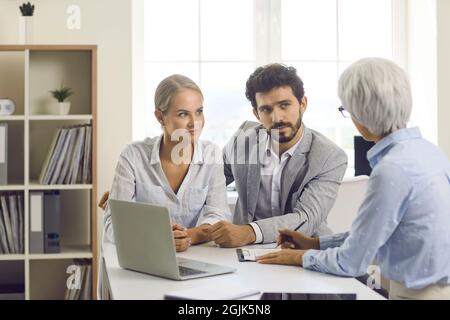 Specialista femminile in prestiti e assistenza finanziaria alle giovani famiglie consiglia la coppia. Foto Stock