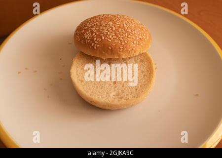 Hamburger di semi di sesamo tagliato a metà pronto Foto Stock