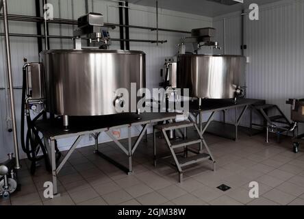 Interno di caseificio con vasca di fermentazione. Attrezzature tecnologiche presso la fattoria del formaggio. Moderna fattoria di formaggio Foto Stock