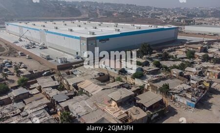 Tijuana, Messico. 4 settembre 2021. Il nuovo magazzino di Amazon è circondato da un muro accanto a un quartiere più povero. Credit: Stringer/dpa/Alamy Live News Foto Stock