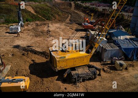 Escavatori gialli alla costruzione di una nuova strada a Kazan, Russia. Macchine per costruzioni Foto Stock