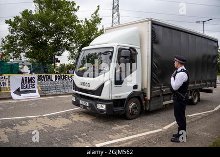 Cartello di passaggio camion che protesta contro la fiera DSEI Arms Fair Trade Show di Defense & Security Equipment International, Excel, Londra, Regno Unito. Polizia Foto Stock