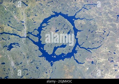 CRATERE DI IMPATTO MANICOUAGAN. Fotografato nel 2011. Manicouagan Reservoir (anche il lago Manicouagan) è un lago anulare nel Québec centrale, Canada, che copre un'area di 750ÊsqÊmiles. L'isola lacustre nel suo centro è conosciuta come René-Levasseur Island, e il suo punto più alto è il Monte Babel. La struttura è stata creata 214 (±1) milioni di anni fa, nel tardo Triassico, dall'impatto di un meteorite 3Êmiles in diametro. Il lago e l'isola sono chiaramente visibili dallo spazio e talvolta sono chiamati "occhio del Québec". Una versione ottimizzata e potenziata digitalmente di un'immagine NASA / credito NASA Foto Stock