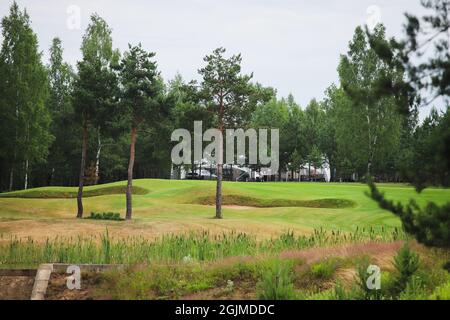 Lago circondato dal verde sul territorio del golf club. Serbatoio artificiale. Foto Stock