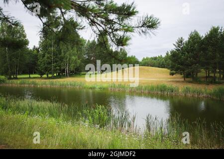 Lago circondato dal verde sul territorio del golf club. Serbatoio artificiale. Foto Stock