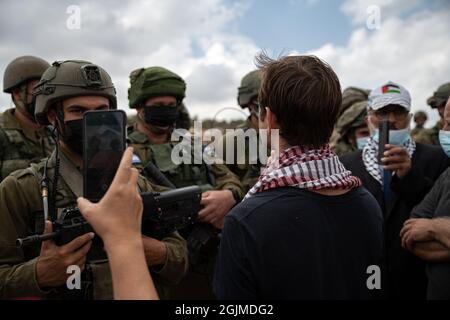 Salfit, Palestina. 10 Settembre 2021. I palestinesi del villaggio di Salfit protestano davanti ai soldati armati israeliani, contro il saccheggio delle loro terre da parte di un nuovo avamposto ebraico in Cisgiordania. Mentre la gente del posto ha fatti di terra che provano la loro proprietà sulla terra - l'IDF sta impedendo il loro accesso alla terra mentre sta sorvegliando l'avamposto ebraico. Salfit, Israele / Palestina, l'11 settembre 2021. (Foto di Matan Golan/Alamy Live News) Credit: Matan Golan/Alamy Live News Foto Stock