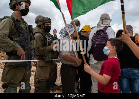 Salfit, Palestina. 10 Settembre 2021. I palestinesi del villaggio di Salfit protestano davanti ai soldati armati israeliani, contro il saccheggio delle loro terre da parte di un nuovo avamposto ebraico in Cisgiordania. Mentre la gente del posto ha fatti di terra che provano la loro proprietà sulla terra - l'IDF sta impedendo il loro accesso alla terra mentre sta sorvegliando l'avamposto ebraico. Salfit, Israele / Palestina, l'11 settembre 2021. (Foto di Matan Golan/Alamy Live News) Credit: Matan Golan/Alamy Live News Foto Stock