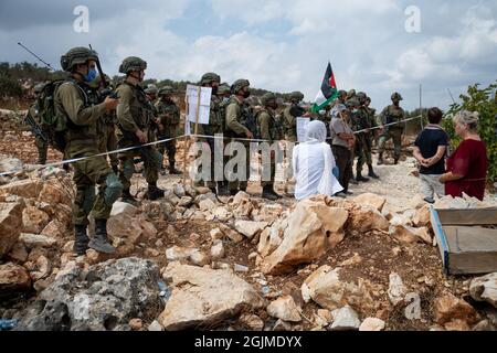 Salfit, Palestina. 10 Settembre 2021. I palestinesi del villaggio di Salfit protestano davanti ai soldati armati israeliani, contro il saccheggio delle loro terre da parte di un nuovo avamposto ebraico in Cisgiordania. Mentre la gente del posto ha fatti di terra che provano la loro proprietà sulla terra - l'IDF sta impedendo il loro accesso alla terra mentre sta sorvegliando l'avamposto ebraico. Salfit, Israele / Palestina, l'11 settembre 2021. (Foto di Matan Golan/Alamy Live News) Credit: Matan Golan/Alamy Live News Foto Stock