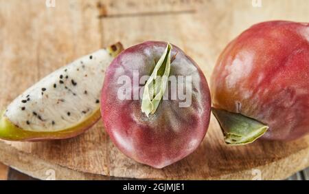 Frutta di cactus di mela peruviana intera e tagliata su supporto di legno su tavola grigia. Nome scientifico Cereus repandus. Foto Stock