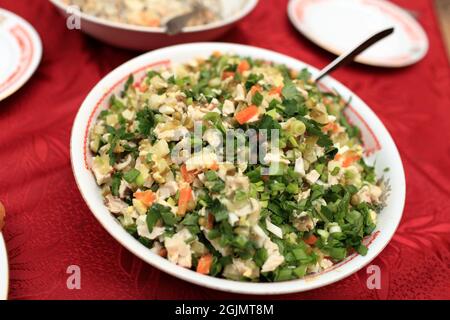 L'insalata Olivier viene preparata con patate a dadini, verdure, uova e prosciutto Foto Stock