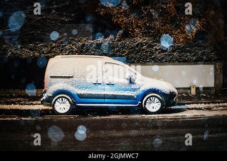 Nevicare sopra il coperto con morbida auto blu Citroen mini furgone Foto Stock
