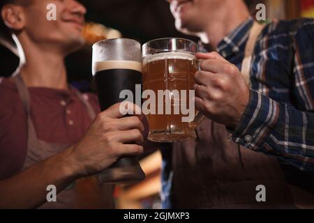 Primo piano dei birrifici che si accalcano i bicchieri da birra Foto Stock