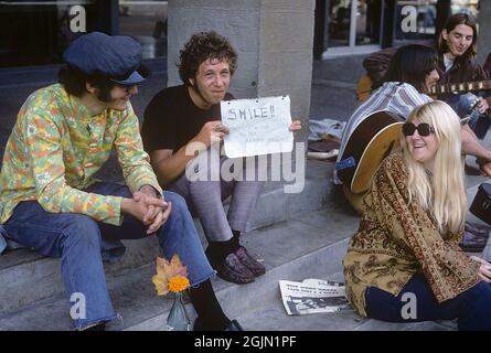 USA dicembre 1968. Studenti all'Università della California Berkeley in 1968 abiti tipici. Il giovane ha un cartello scritto a mano con il messaggio: Sorridi!! C'è molto di cui essere felici!! 6-1-19 Credit Roland Palm Ref 6-1-14 Foto Stock