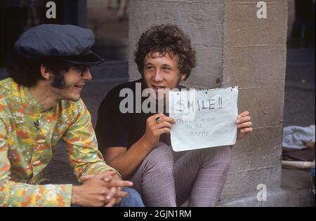 USA dicembre 1968. Studenti all'Università della California Berkeley in 1968 abiti tipici. Il giovane ha un cartello scritto a mano con il messaggio: Sorridi!! C'è molto di cui essere felici!! 6-1-19 Credit Roland Palm Ref 6-1-13 Foto Stock