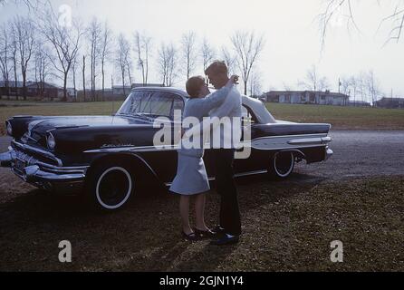 USA negli anni '60. Una giovane coppia accanto ad un capo stella Pontiac, un modello che fu prodotto da Pontiac tra il 1954 e il 1966. La vettura è stata facilmente identificata dal rivestimento a stella cromato lungo i lati. Kodachrome vetrino originale. Credit Roland Palm Ref 6-9-18 Foto Stock