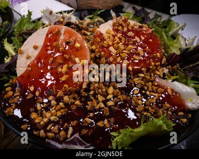 Antipasto foie gras guarnito con verdure. Diverse padelle d'anatra con erbe e marmellata, servito sul piatto su un tavolo in un ristorante con arredamento. Foto Stock