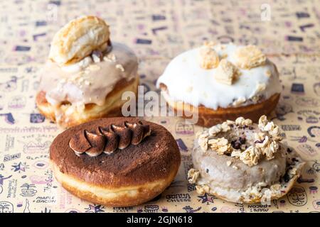 Diversi tipi di ciambelle su carta da forno, cibo Foto Stock