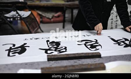 Calligrafia cinese che pratica le sue abilità calligrafiche-Shuyuanmen Antica Cultura-Calligraphy Street. XI'an-China-1571 Foto Stock