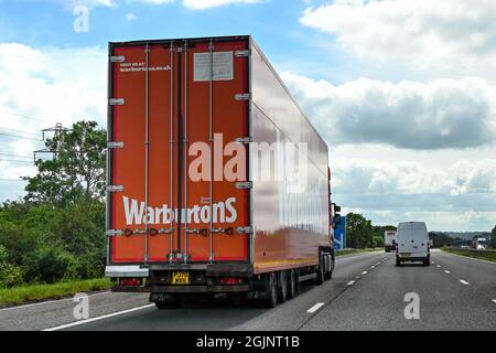 Swindon, Inghilterra - Giugno 2021: Autocarro articolato con lato alto a scatola gestito dal produttore di pane Warburtons che guida sull'autostrada M4 Foto Stock