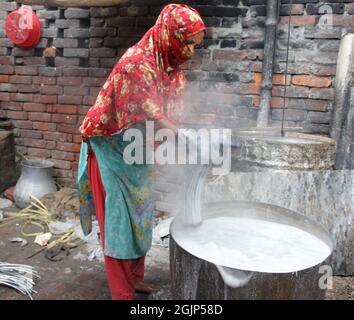 Non esclusiva: CITTÀ DI DHAKA, BANGLADESH, 9 SETTEMBRE: I lavoratori hanno battuto l'acqua di stoffa lungo un fiume inquinato. I lavoratori lavano, squillano fuori e asciugano il panno alon Foto Stock