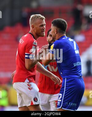 Jayden Stockley di Charlton Athletic (a sinistra) e Cheltenham Town Sean Long si scontrano durante la partita della Sky Bet League One a The Valley, Londra. Data foto: Sabato 11 settembre 2021. Foto Stock