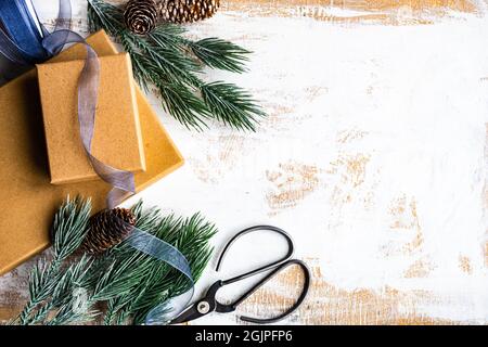 Il concetto di scheda di Natale con cornice fatta con rami di abete verde, palline da decorazione rosse e bacche su fondo di calcestruzzo Foto Stock