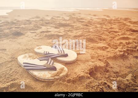 Infradito su una spiaggia sabbiosa di mare Foto Stock