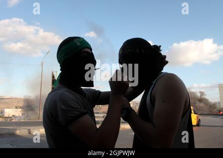Cisgiordania, Nablus, Palestina. 11 Settembre 2021. Un ventilatore palestinese mascherato di sigarette durante la manifestazione. I dimostranti palestinesi dimostrano solidarietà con i prigionieri palestinesi detenuti nelle carceri israeliane vicino al checkpoint di Hawara, a sud di Nablus in Cisgiordania, e ci sono circa 5,000 prigionieri nelle carceri israeliane. Credit: Nasser Ishtayeh/ZUMA Wire/Alamy Live News Foto Stock