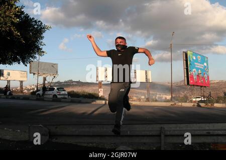Nablus, Palestina. 11 Settembre 2021. Un palestinese mascherato ha visto gettare pietre durante la dimostrazione. I palestinesi hanno tenuto una manifestazione solidale con i prigionieri palestinesi detenuti nelle carceri israeliane vicino al checkpoint di Hawara, a sud di Nablus in Cisgiordania, e ci sono circa 5,000 prigionieri nelle carceri israeliane. Credit: SOPA Images Limited/Alamy Live News Foto Stock