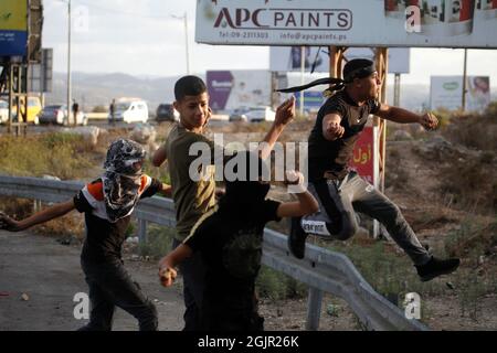 Nablus, Palestina. 11 Settembre 2021. I palestinesi si vedono gettare pietre durante la manifestazione. I palestinesi hanno tenuto una manifestazione solidale con i prigionieri palestinesi detenuti nelle carceri israeliane vicino al checkpoint di Hawara, a sud di Nablus in Cisgiordania, e ci sono circa 5,000 prigionieri nelle carceri israeliane. (Foto di Nasser Ishtayeh/SOPA Images/Sipa USA) Credit: Sipa USA/Alamy Live News Foto Stock