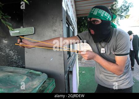 Cisgiordania, Nablus, Palestina. 11 Settembre 2021. Un palestinese mascherato gettando pietre durante la manifestazione. I dimostranti palestinesi dimostrano solidarietà con i prigionieri palestinesi detenuti nelle carceri israeliane vicino al checkpoint di Hawara, a sud di Nablus in Cisgiordania, e ci sono circa 5,000 prigionieri nelle carceri israeliane. Credit: Nasser Ishtayeh/ZUMA Wire/Alamy Live News Foto Stock