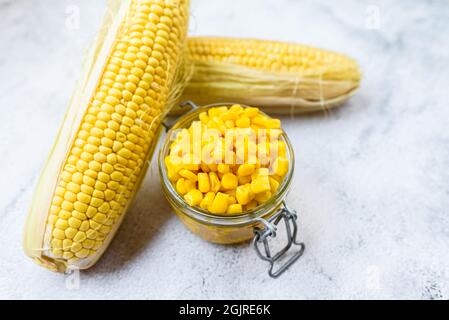 I chicchi di mais dolci vengono bolliti e confezionati in lattine per preservarne il sapore e le proprietà nutrizionali. Foto Stock