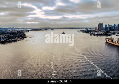 La nave parte dal porto di San Diego, passando per l'isola di Coronado e lo skyline. Foto Stock