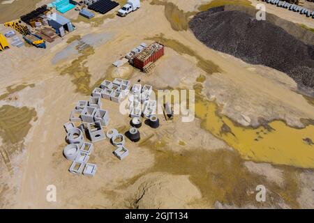 Vista aerea panoramica dei lavori di preparazione del terreno sotto l'area di costruzione con la posa di botole di drenaggio per l'impianto idrico Foto Stock