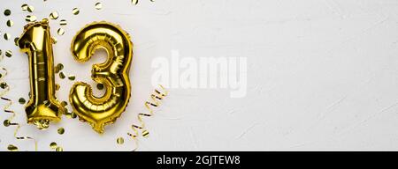 palloncino dorato numero tredici. Tessera di compleanno o anniversario con l'iscrizione 13. Sfondo grigio in cemento. Celebrazione dell'anniversario. Banner. Foto Stock