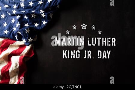 Martin Luther King Day anniversario concetto. Bandiera americana su sfondo di pietra scura Foto Stock