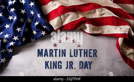 Martin Luther King Day anniversario concetto. Bandiera americana su sfondo di pietra scura Foto Stock