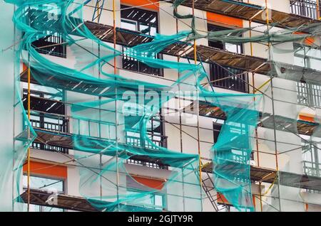 Impalcatura su una casa di recente costruzione e rete verde allungata Foto Stock