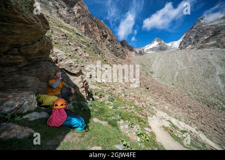 Fare una pausa all'ombra mentre si torna verso la stazione di risalita di Kreuzboden dopo l'arrampicata su roccia del monte Jegihorn, Saas-Grund, Svizzera Foto Stock